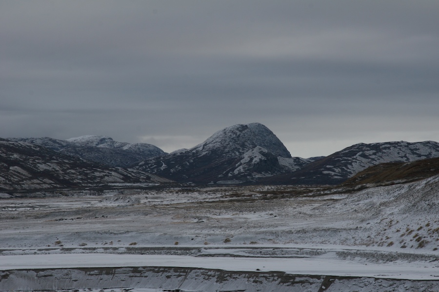 The diffuse grays of an overcast Greenland morning create a monotone landscape surrounding Mount Keglen.