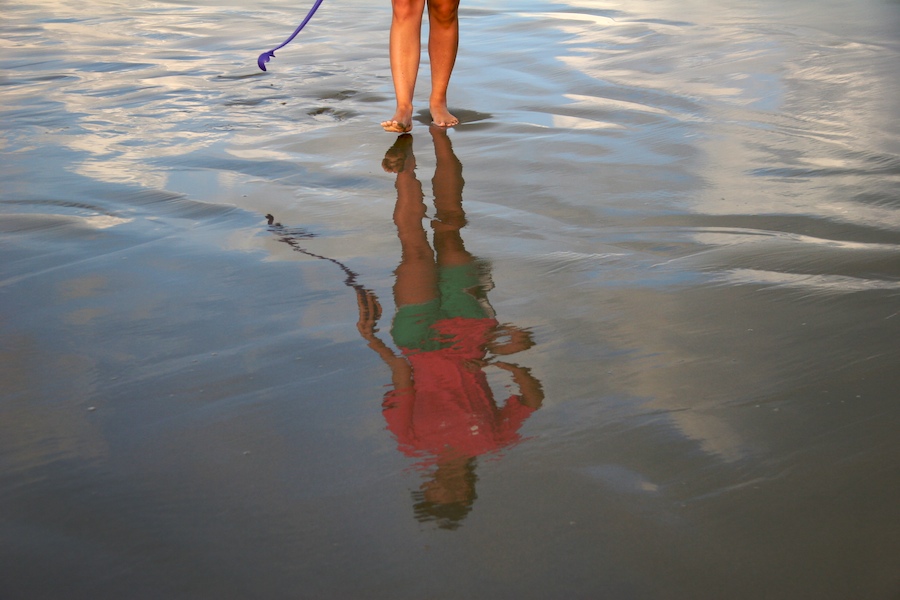 With the tide just departed, an early morning stroller casts a reflection on the beach on Sullivan's Island, SC.